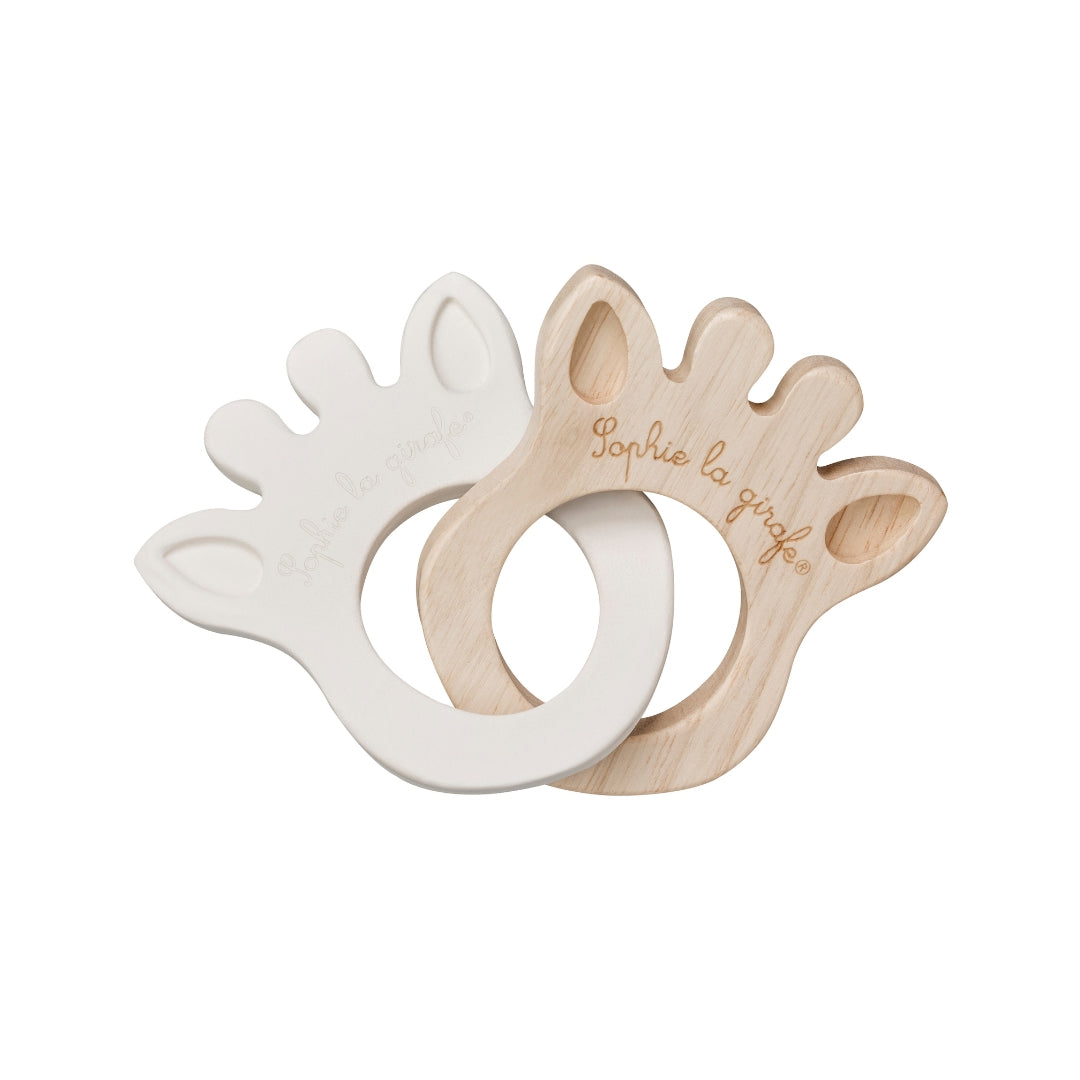 Two wooden baby teething rings, one white and one natural wood, on a white background.