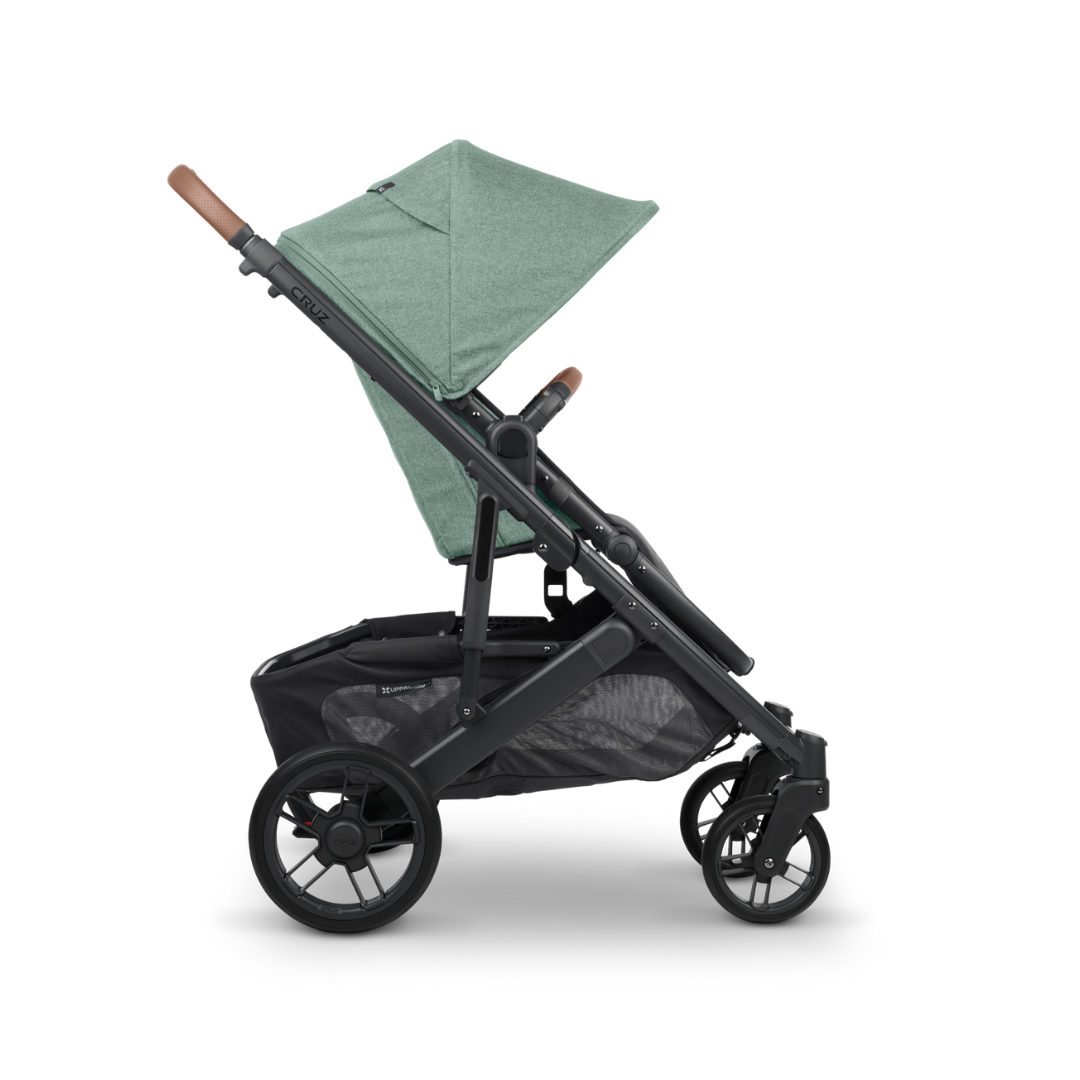 UPPAbaby Cruz V2 Stroller in Gwen Green Melange Fabric, Carbon Frame and Saddle Leather detail on handle and bumper bar. Side on.