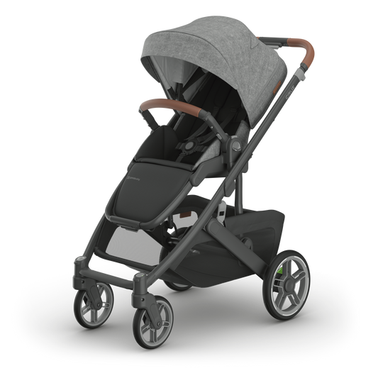 UPPAbaby Cruz V3 stroller with charcoal canopy and carbon frame with tan leather accents side on on a white background.