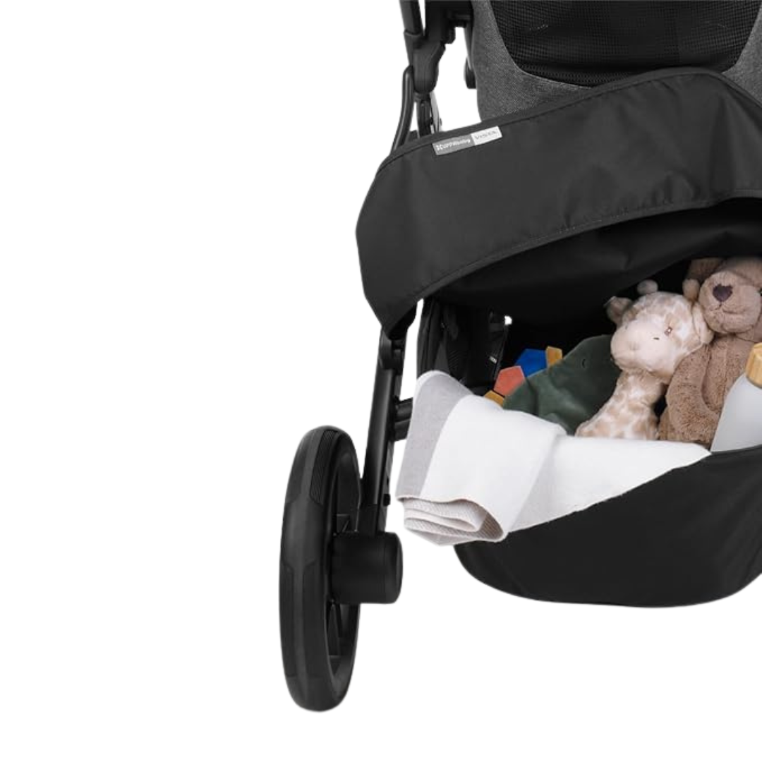 Black strolle with UPPAbaby basekt cover with toys and a blanket inside on a white background