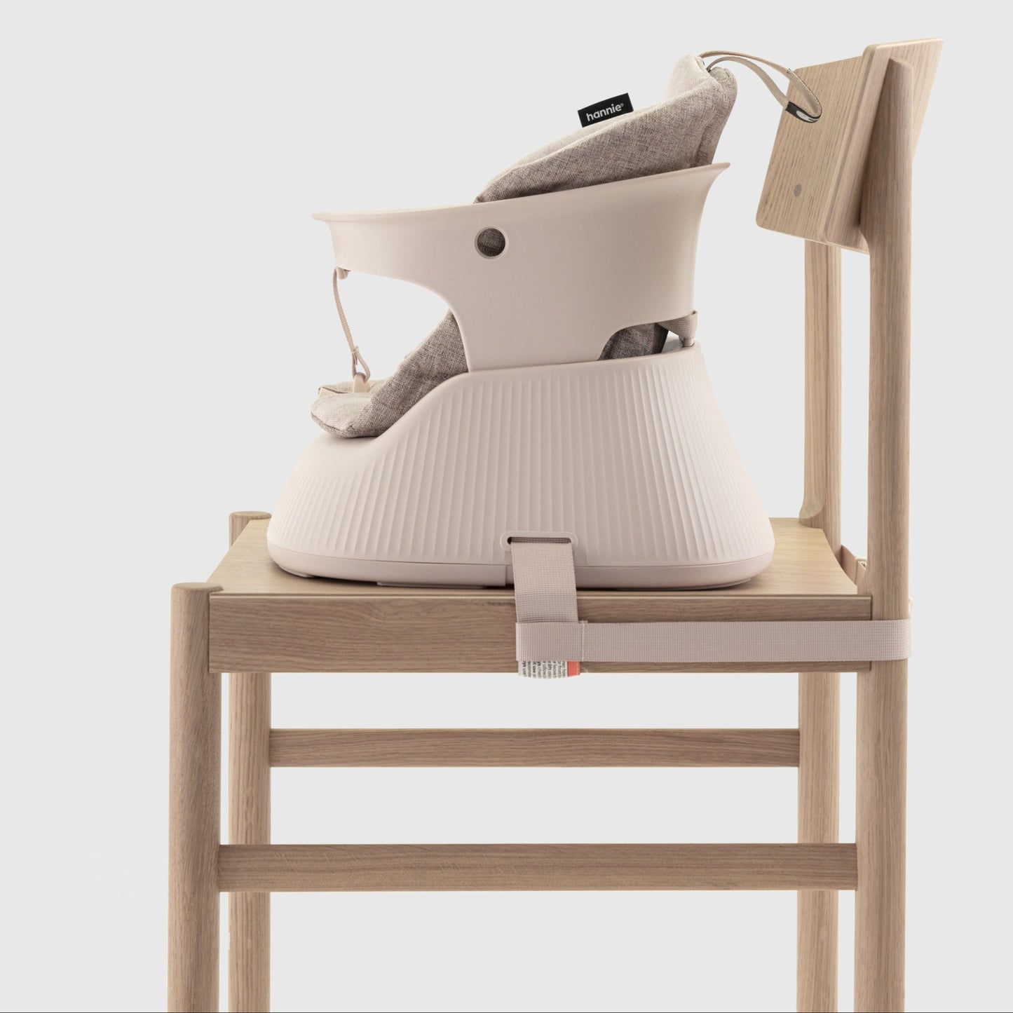 Baby high chair with a beige cushion  attached to a chair on a white background