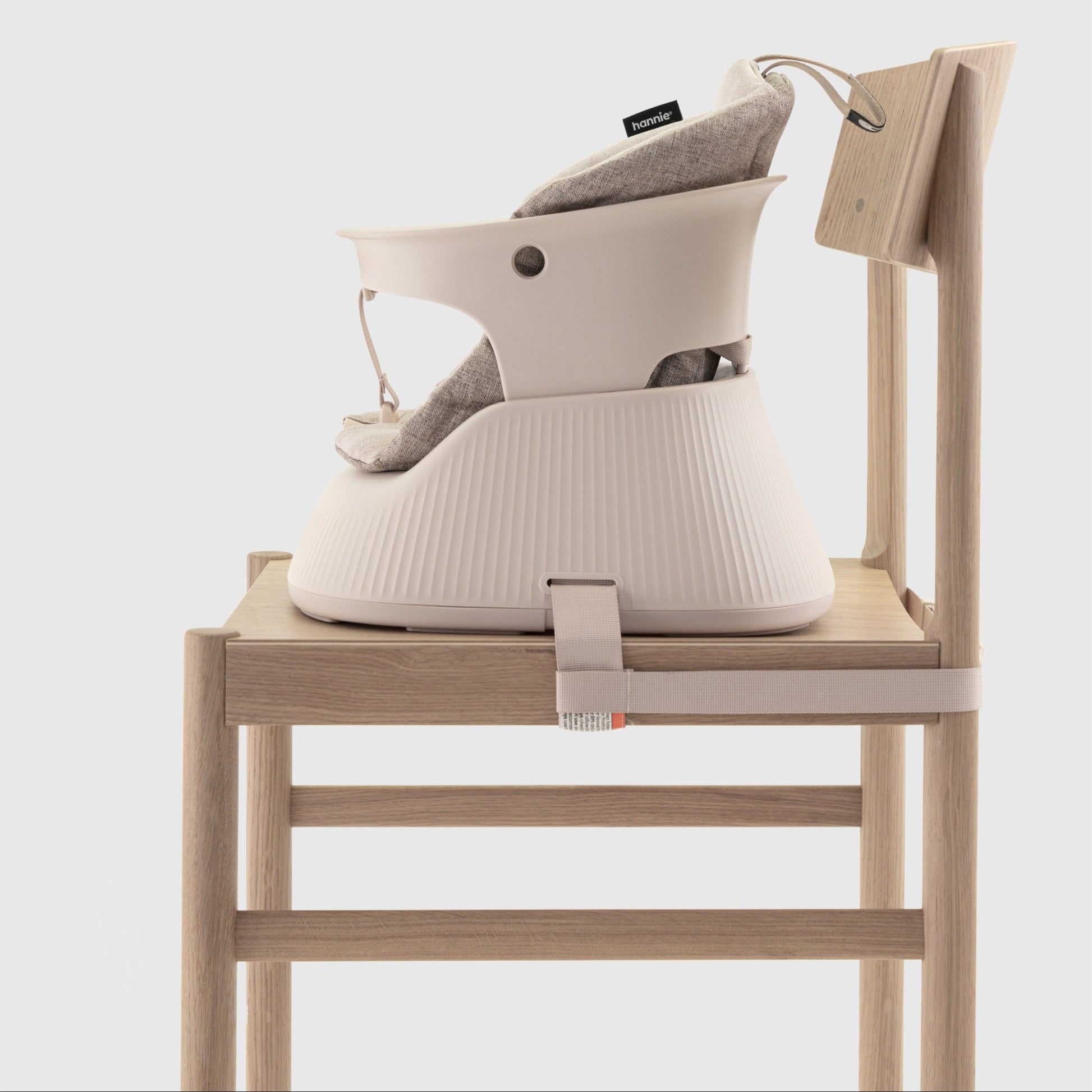 Baby high chair with a beige cushion  attached to a chair on a white background