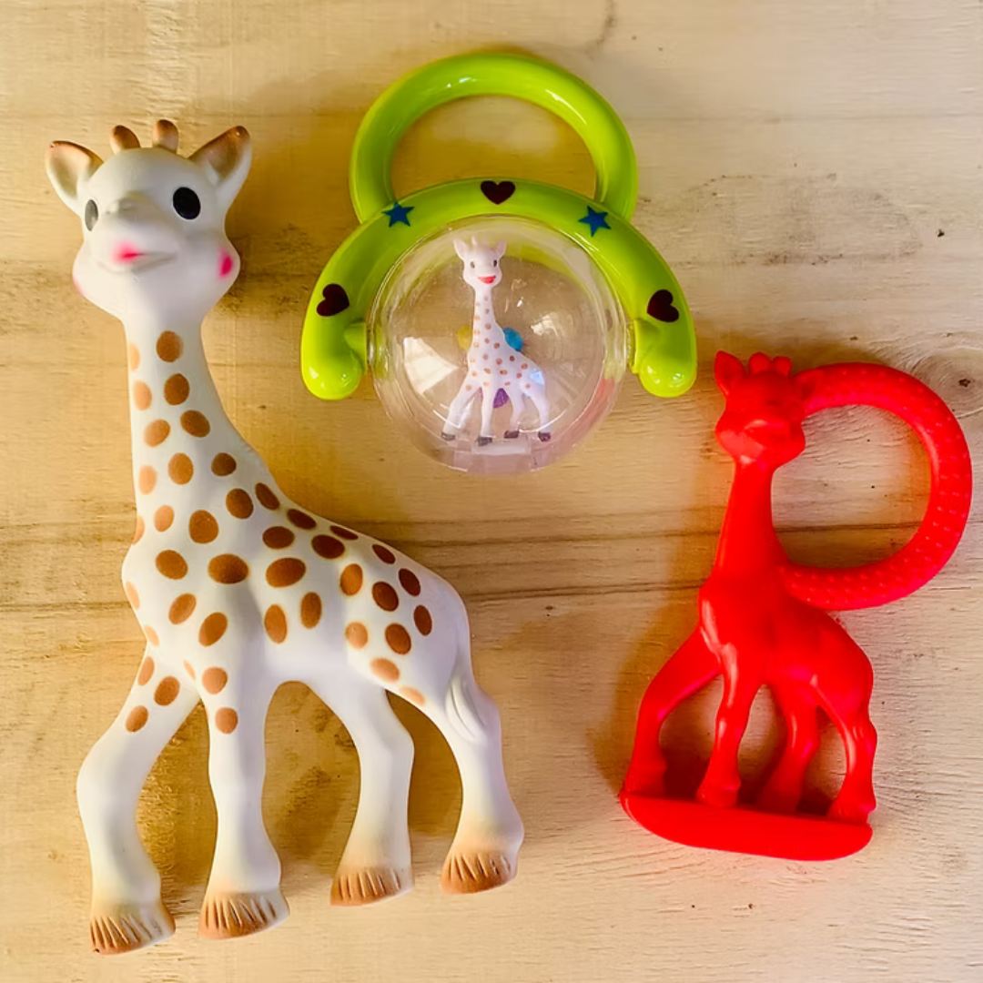 Three giraffe toys on a wooden surface