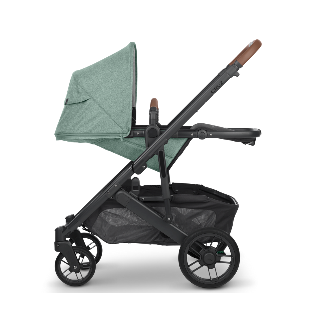 UPPAbaby Cruz V2 Stroller in Gwen Green Melange Fabric, Carbon Frame and Saddle Leather detail on handle and bumper bar.  Reclined Seat Position.  