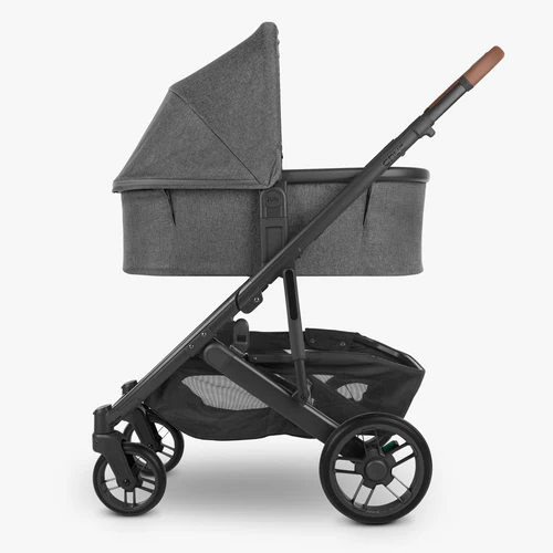 Gray stroller with a canopy on a white background with adapters attached to stroller with bassinet.  