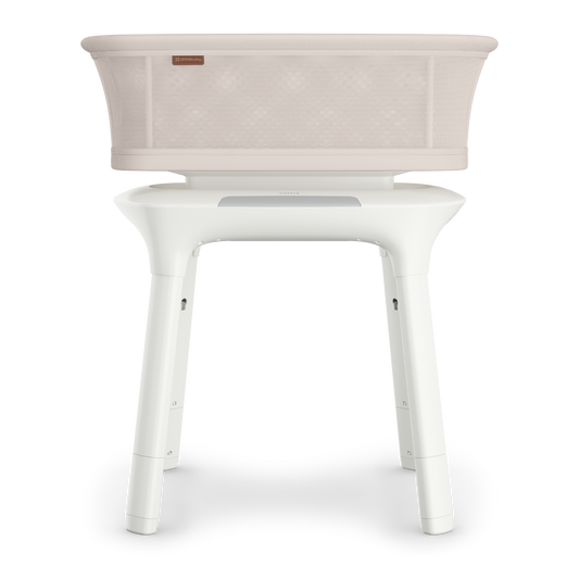 UPPAbaby sand coloured mesh  baby bassinet with white legs a white background.