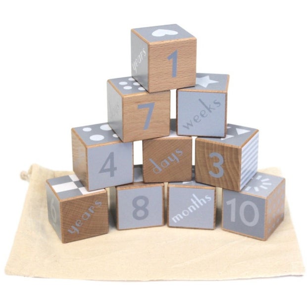 Wooden blocks with milestone numbers and text on a white background